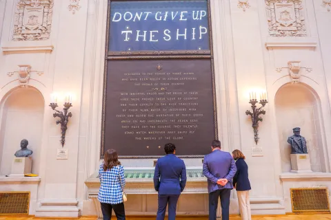 Members look at Naval Academy plaque