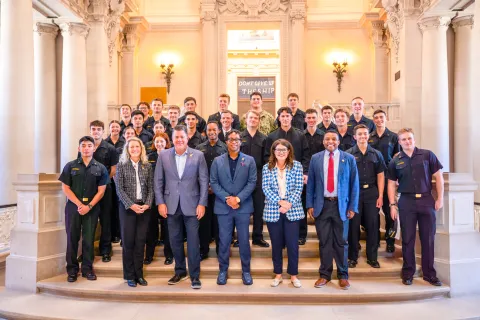 Members pose with midshipmen from their Districts at Naval Academy